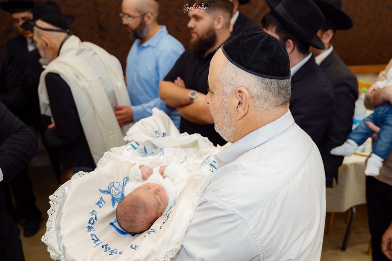 סבא מחזיק את הנכד בברית